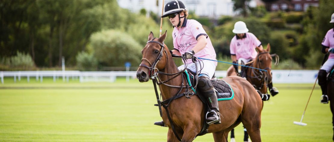 Photo of woman riding a horse playing polo